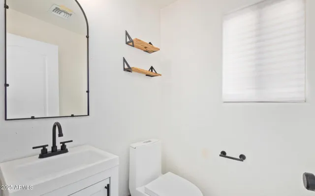 a bathroom with a sink mirror and toilet