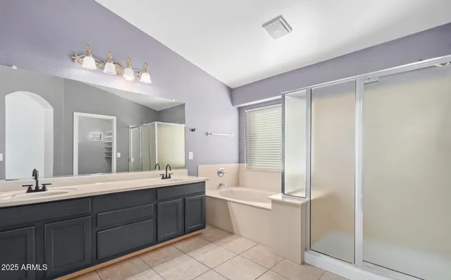 a bathroom with a double vanity sink mirror and bathtub