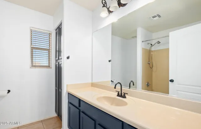a bathroom with a sink vanity granite tub shower and a mirror