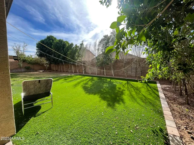 a backyard of a house with table and chairs