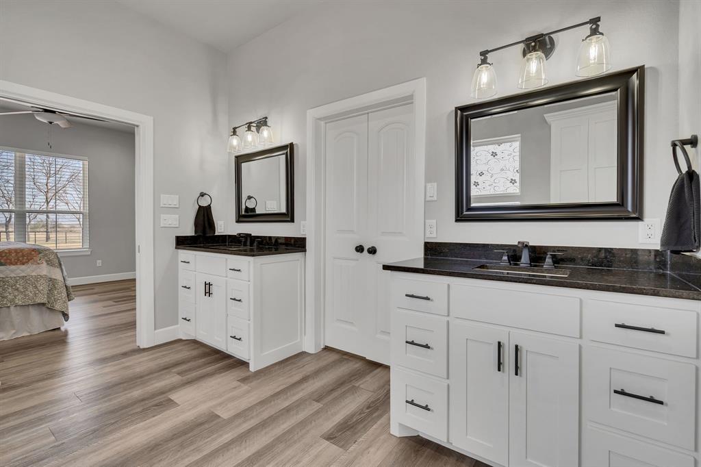 7739 Borth Road Sanger, TX 76266 - Photo 17 of 39 Full bathroom with two vanities, light wood-type flooring, and connected bathroom