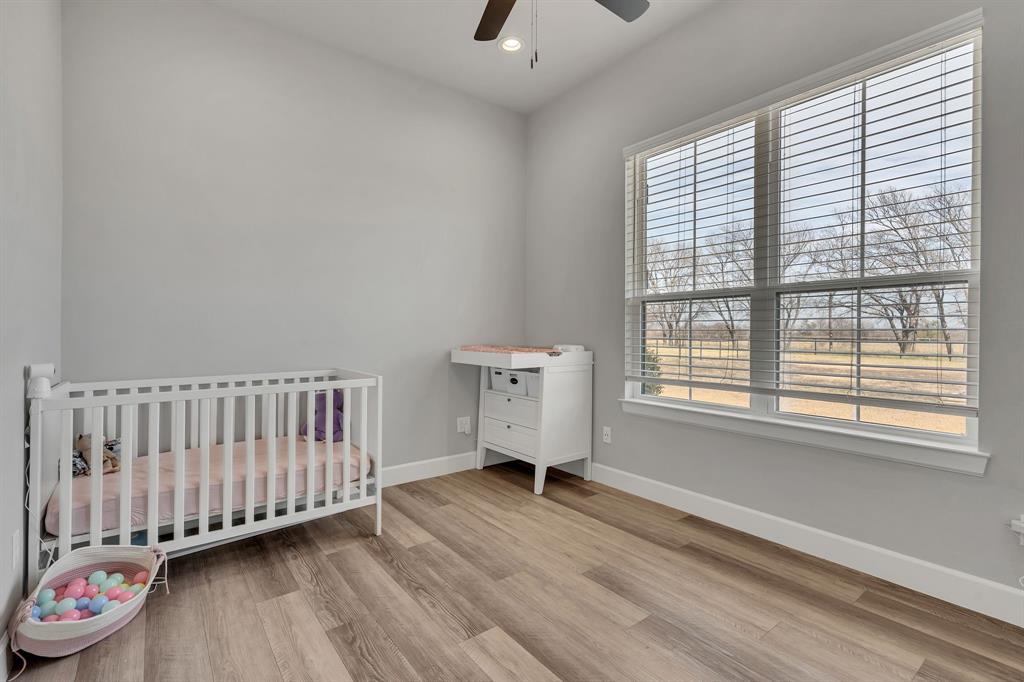7739 Borth Road Sanger, TX 76266 - Photo 20 of 39 Flex Office or Nursery featuring a crib, light wood-style floors, ceiling fan, and recessed lighting