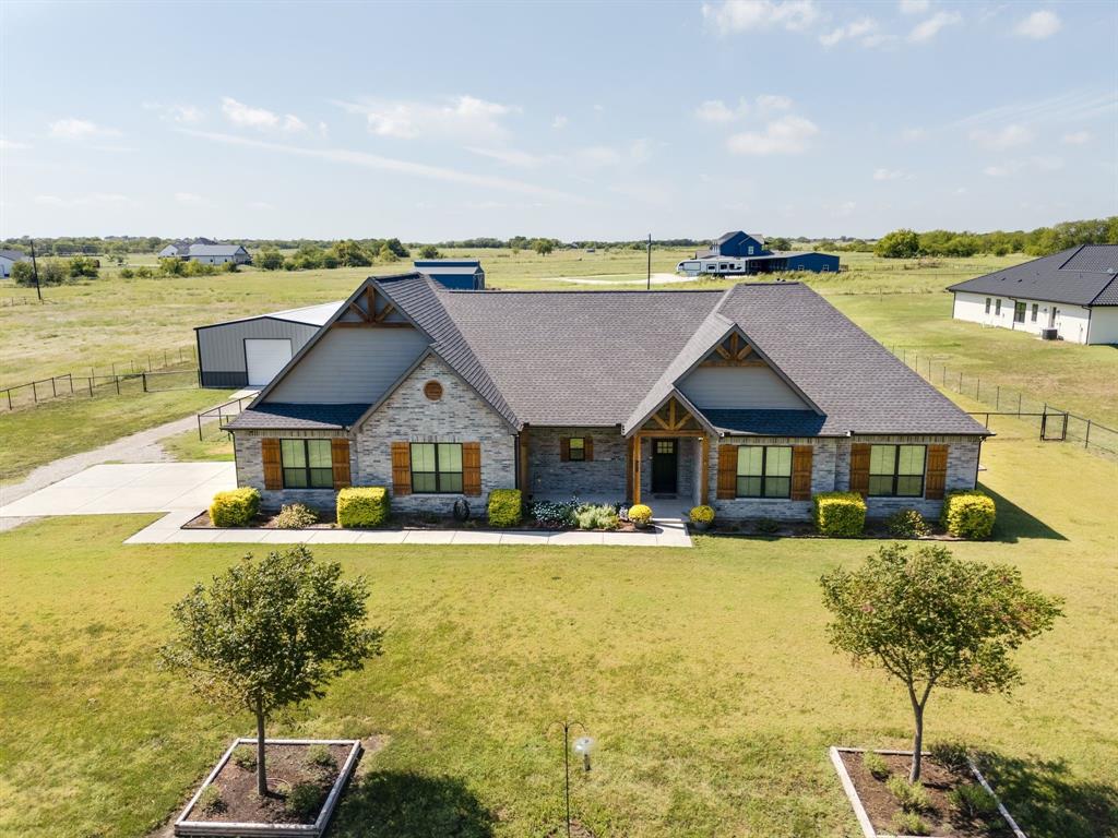 7739 Borth Road Sanger, TX 76266 - Photo 33 of 39 Craftsman house featuring covered porch, stone siding, a view of rural / pastoral area, roof with shingles, and a vegetable garden
