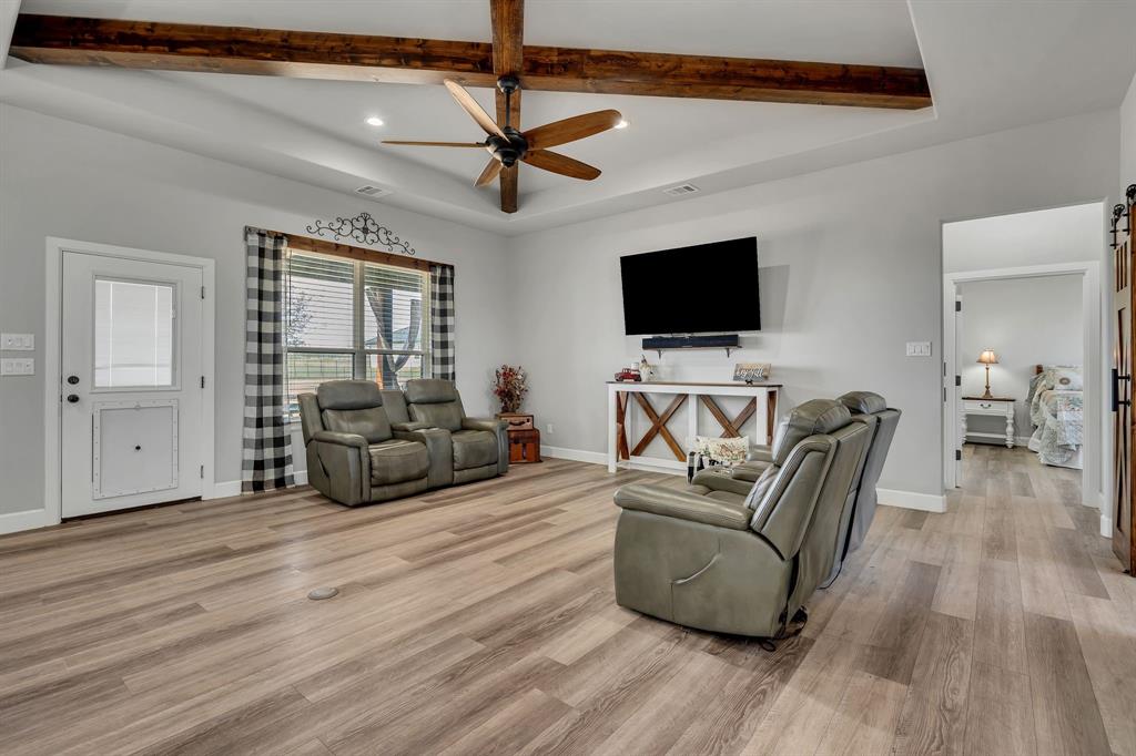 7739 Borth Road Sanger, TX 76266 - Photo 4 of 39 Living room with ceiling fan, recessed lighting, light wood-style flooring, a barn door, and beamed ceiling