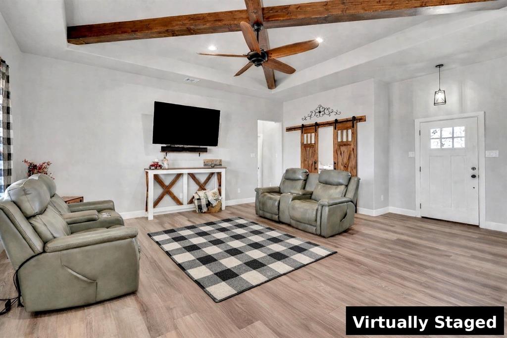 7739 Borth Road Sanger, TX 76266 - Photo 6 of 39 AI generated rug to show potential. Living area with a barn door, light wood finished floors, ceiling fan, recessed lighting, and beam ceiling