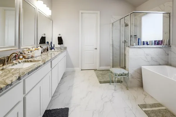 a spacious bathroom with a tub sink and mirror