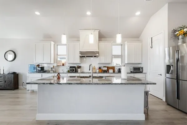 a kitchen with stainless steel appliances granite countertop a stove a sink and a refrigerator