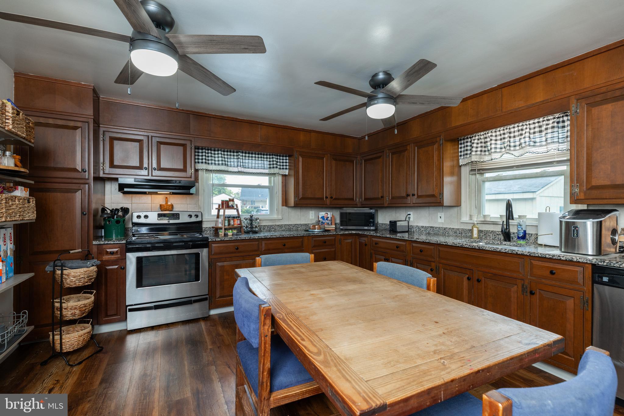 913 Aldon Road Claymont, DE 19703 - Photo 3 of 26 a kitchen with stainless steel appliances granite countertop a stove top oven a sink a dining table and chairs with wooden floor