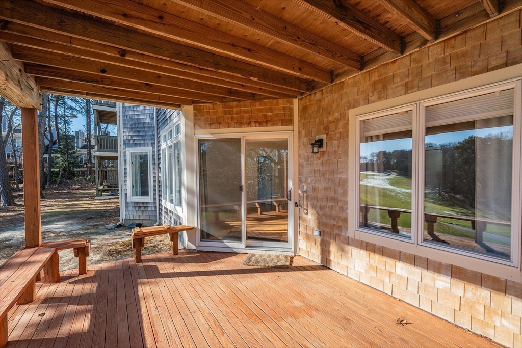 52 Kates Path, Unit 52 Yarmouth, MA 02675 - Photo 30 of 33 a view of a porch with wooden floor and floor to ceiling window