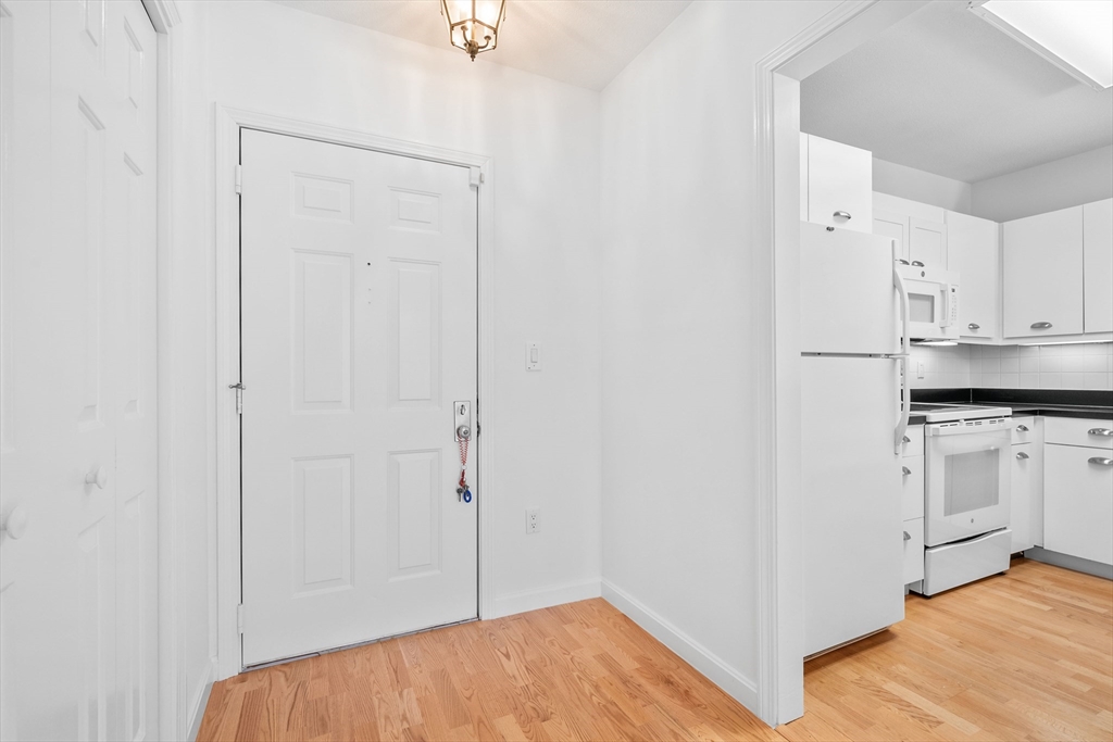 52 Kates Path, Unit 52 Yarmouth, MA 02675 - Photo 9 of 33 a view of a kitchen with white cabinets and wooden floor