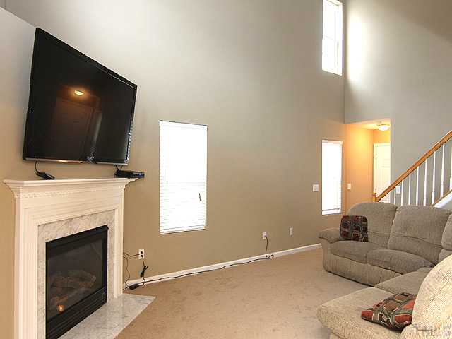 4461 Snowcrest Lane Raleigh, NC 27616 - Photo 2 of 25 a living room with furniture a flat screen tv and a fireplace