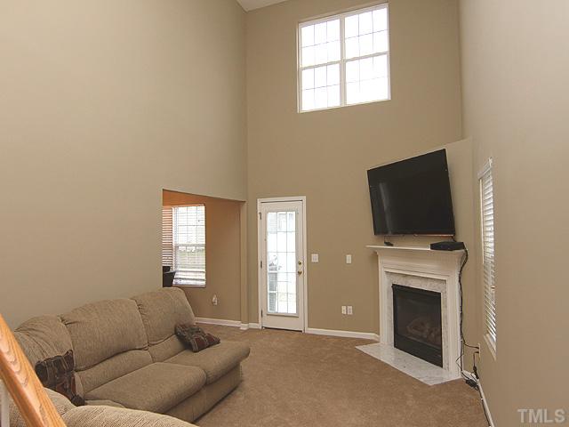 4461 Snowcrest Lane Raleigh, NC 27616 - Photo 3 of 25 a living room with furniture a flat screen tv and a fireplace
