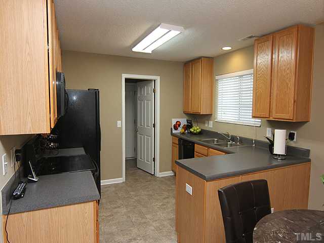 4461 Snowcrest Lane Raleigh, NC 27616 - Photo 5 of 25 a kitchen with a sink stove and refrigerator