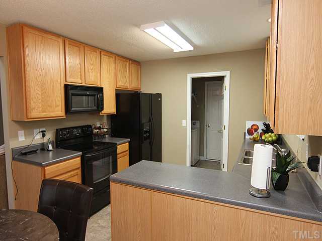 4461 Snowcrest Lane Raleigh, NC 27616 - Photo 6 of 25 a kitchen with stainless steel appliances granite countertop a sink stove and refrigerator