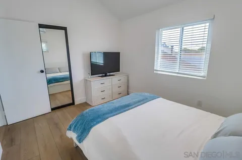 a bedroom with a bed and a flat screen tv