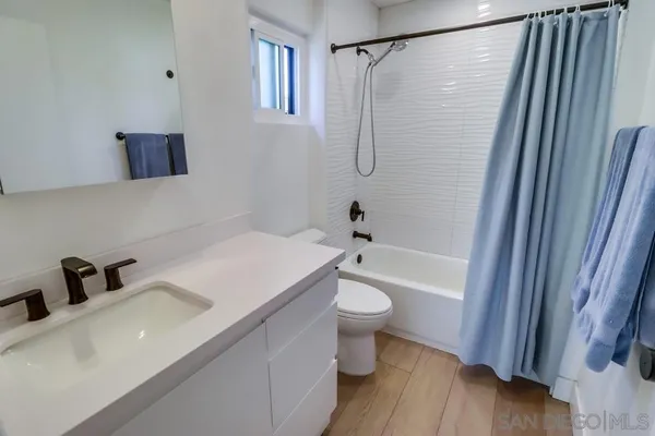 a bathroom with a sink a mirror a toilet and bathtub