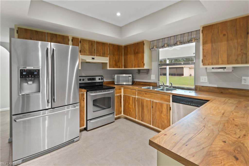 9081 Shaddock Road West Fort Myers, FL 33967 - Photo 6 of 23 a kitchen with a refrigerator sink and stove