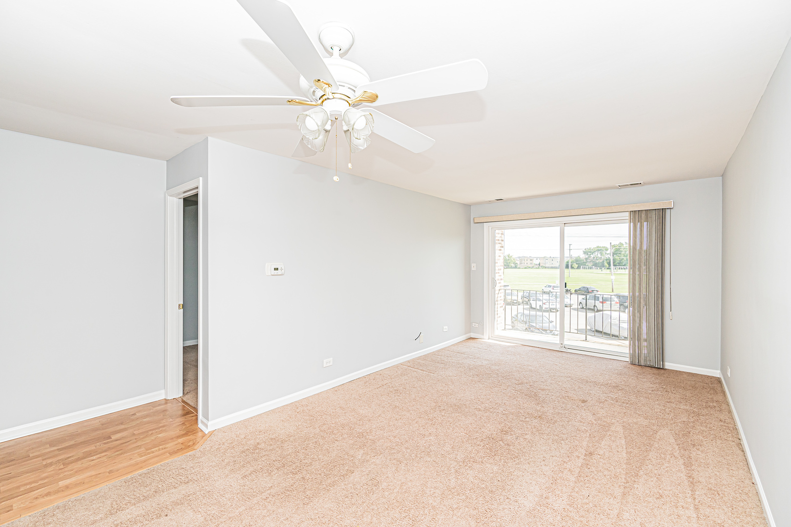 701 West Huntington Commons Road, Unit 211 Mount Prospect, IL 60056 - Photo 3 of 26 an empty room with chandelier fan and windows