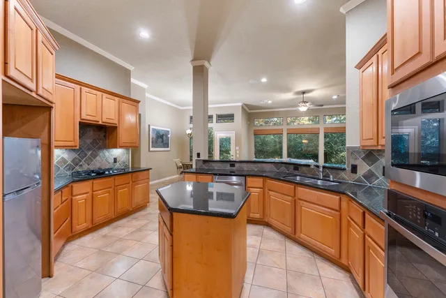 a kitchen with stainless steel appliances granite countertop a sink and a stove