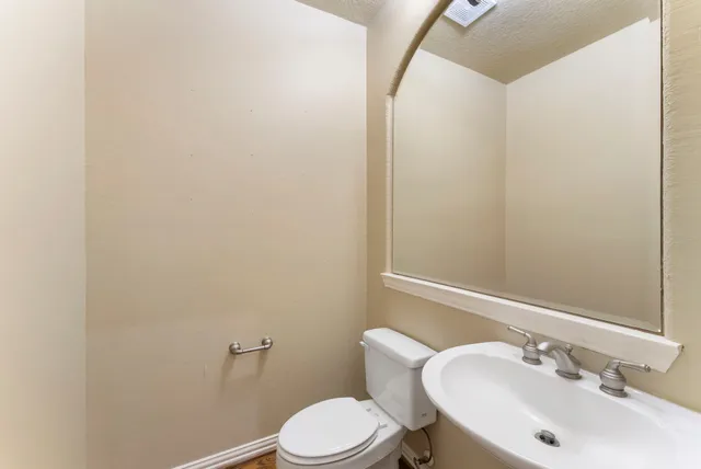 a bathroom with a sink mirror and toilet