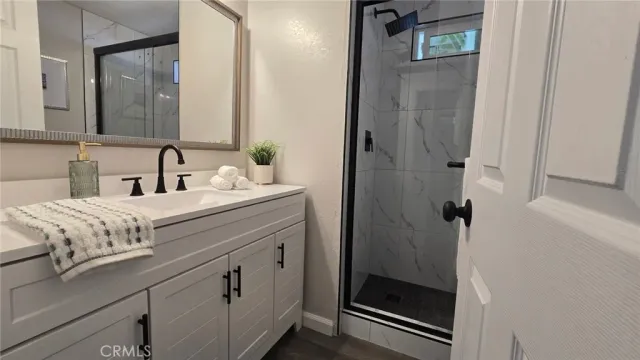 a bathroom with a sink a mirror and shower