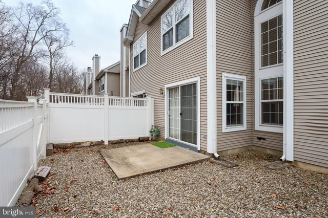 a view of a house with a small yard and wooden fence