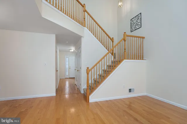 a view of staircase with wooden floor and white walls