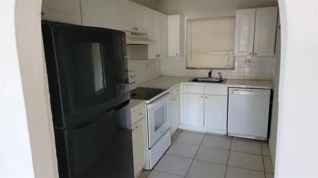 a kitchen with a sink stove and refrigerator