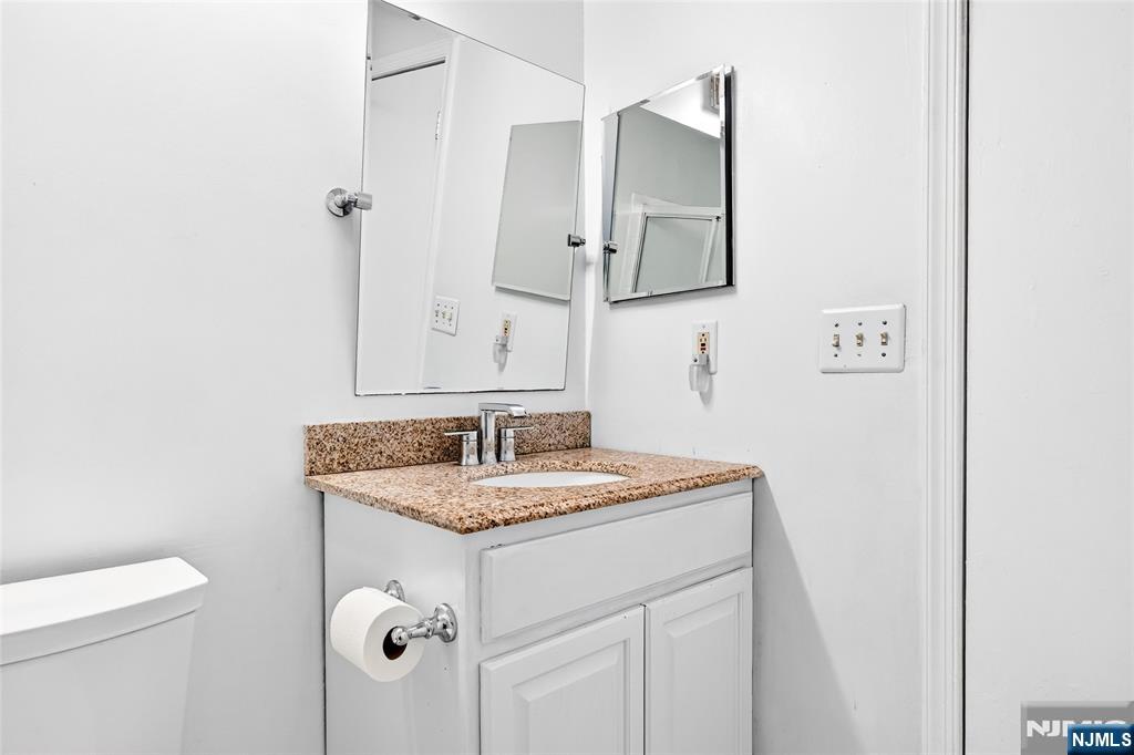 556 Holly Court Mahwah, NJ 07430 - Photo 30 of 46 a bathroom with a granite countertop sink and a mirror
