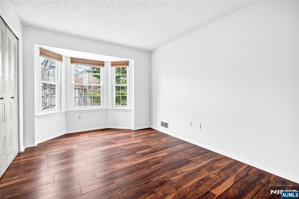 556 Holly Court Mahwah, NJ 07430 - Photo 34 of 46 a view of an empty room with wooden floor and a window