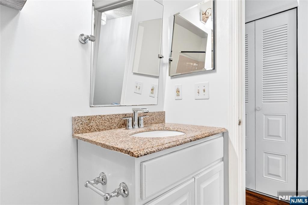556 Holly Court Mahwah, NJ 07430 - Photo 39 of 46 a bathroom with a granite countertop sink and a mirror