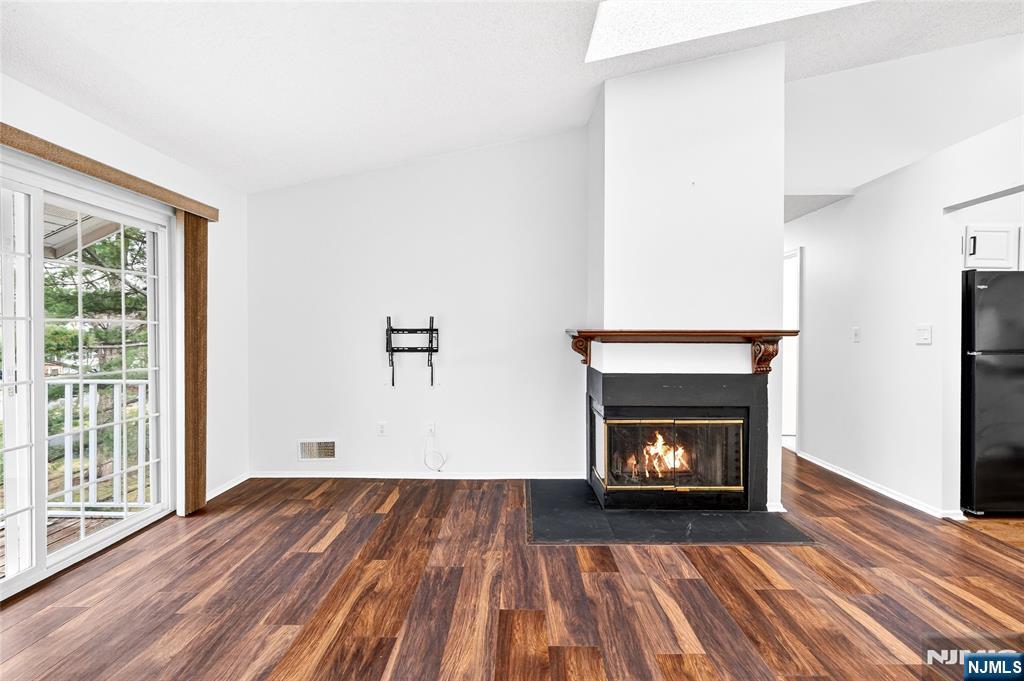 556 Holly Court Mahwah, NJ 07430 - Photo 4 of 46 a view of an empty room with wooden floor fireplace and a window