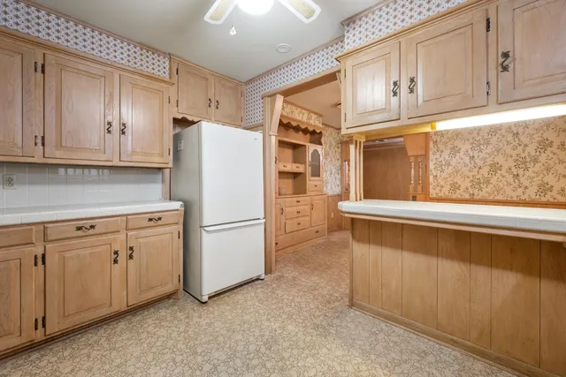 a white refrigerator freezer sitting inside of a kitchen
