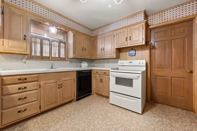 a kitchen with granite countertop cabinets stainless steel appliances and a window