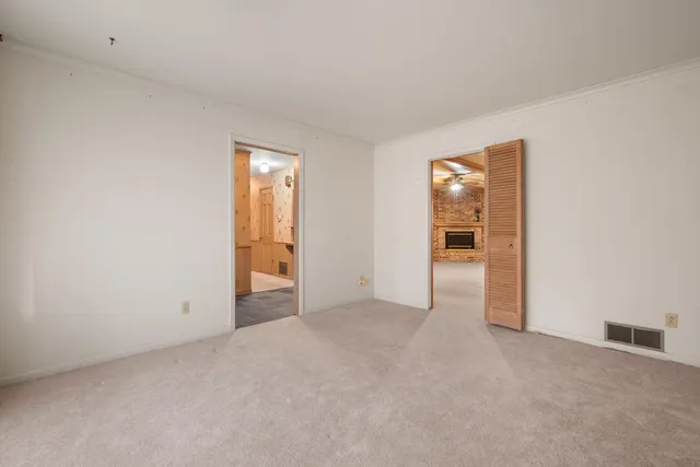 an empty room with closet and windows