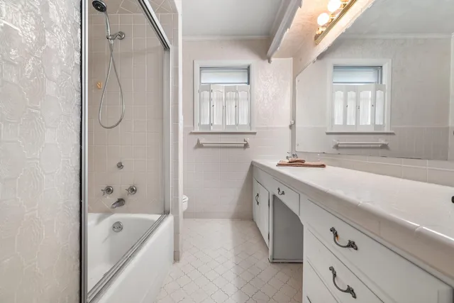 a spacious bathroom with a tub sink and mirror