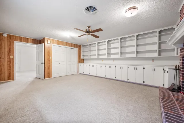 an empty room with a ceiling fan and window