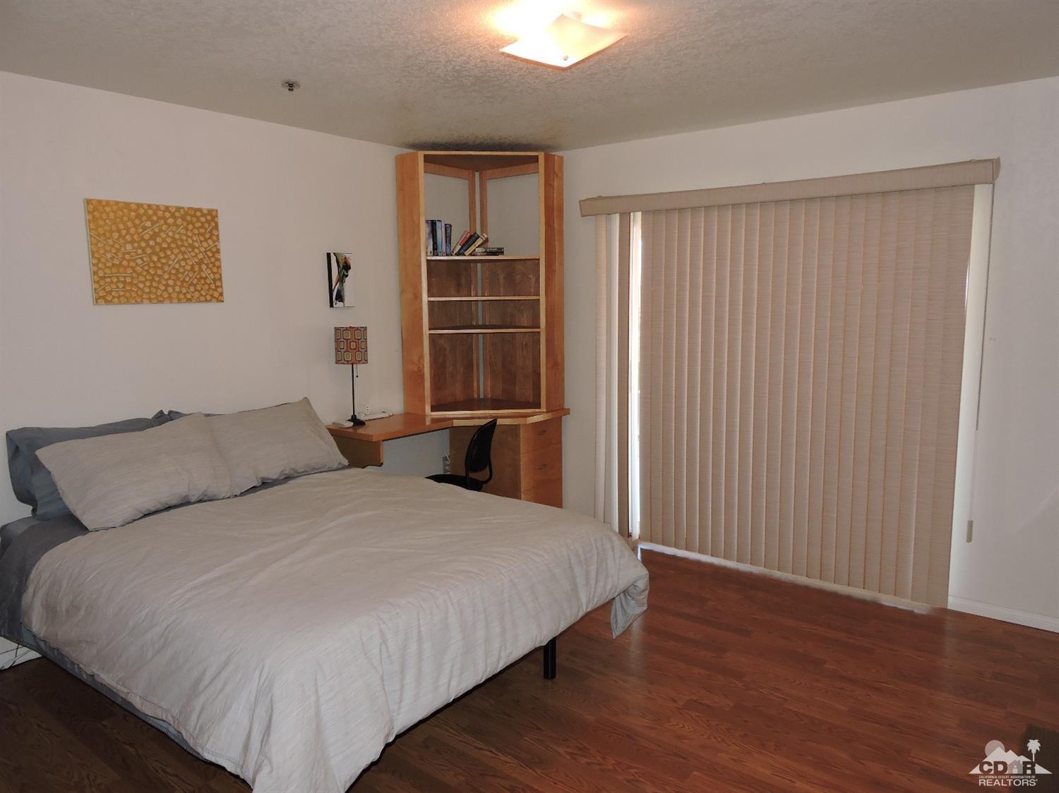 7369 Sunset Road Joshua Tree, CA 92252 - Photo 15 of 37 a bedroom with a bed and wooden floor
