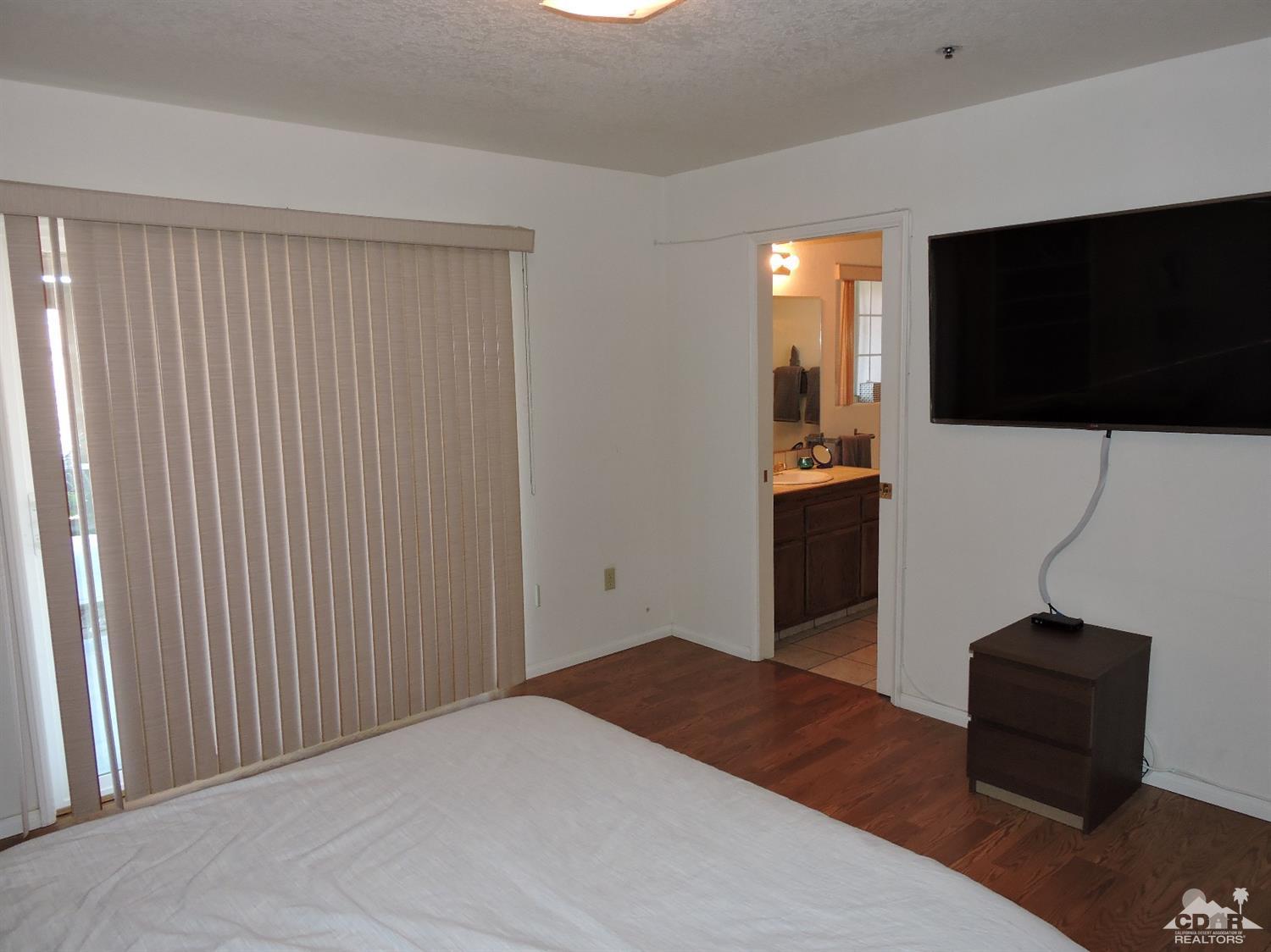 7369 Sunset Road Joshua Tree, CA 92252 - Photo 16 of 37 a bedroom with a bed and a flat screen tv