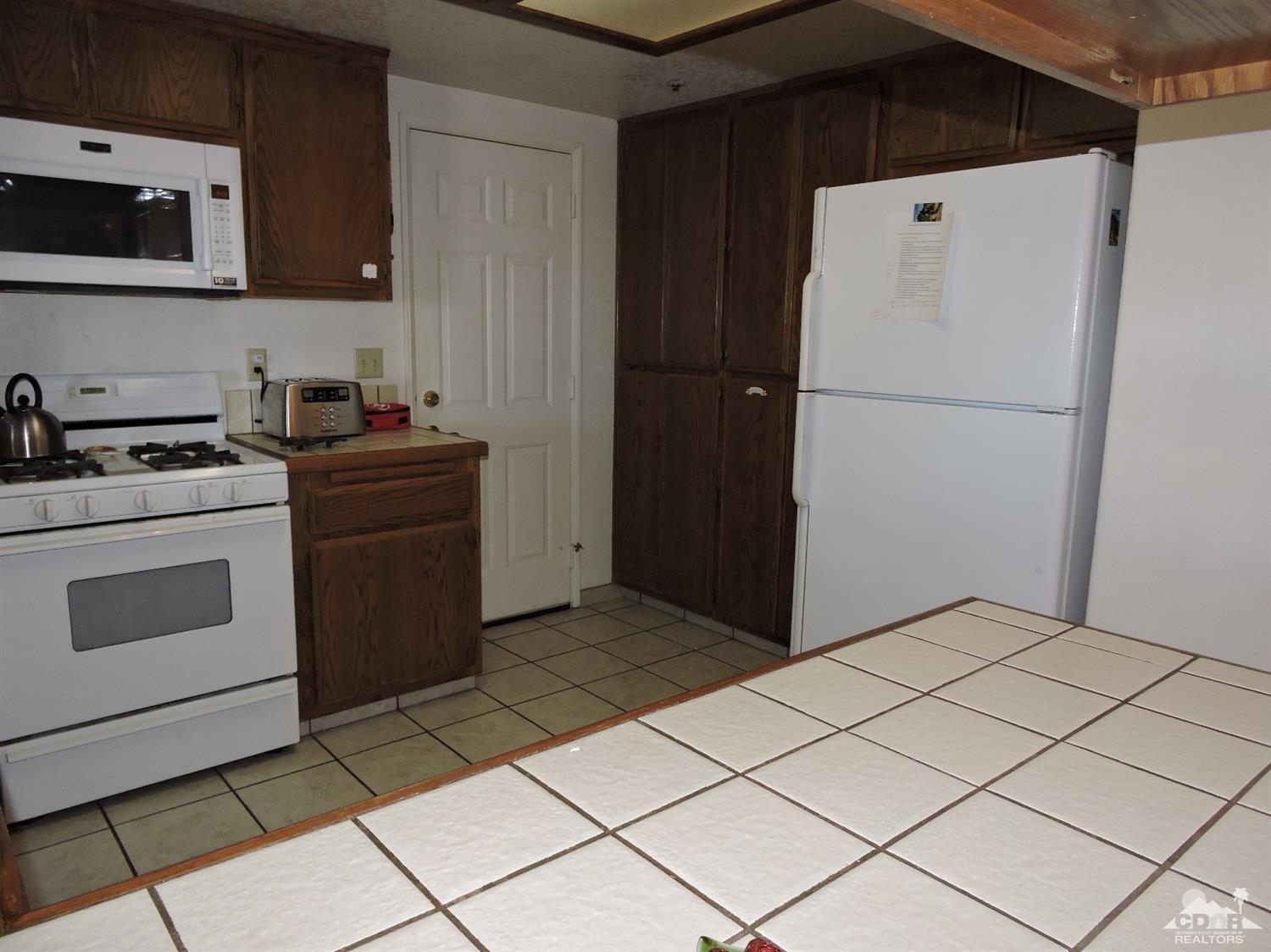 7369 Sunset Road Joshua Tree, CA 92252 - Photo 24 of 37 a kitchen with a stove and a refrigerator