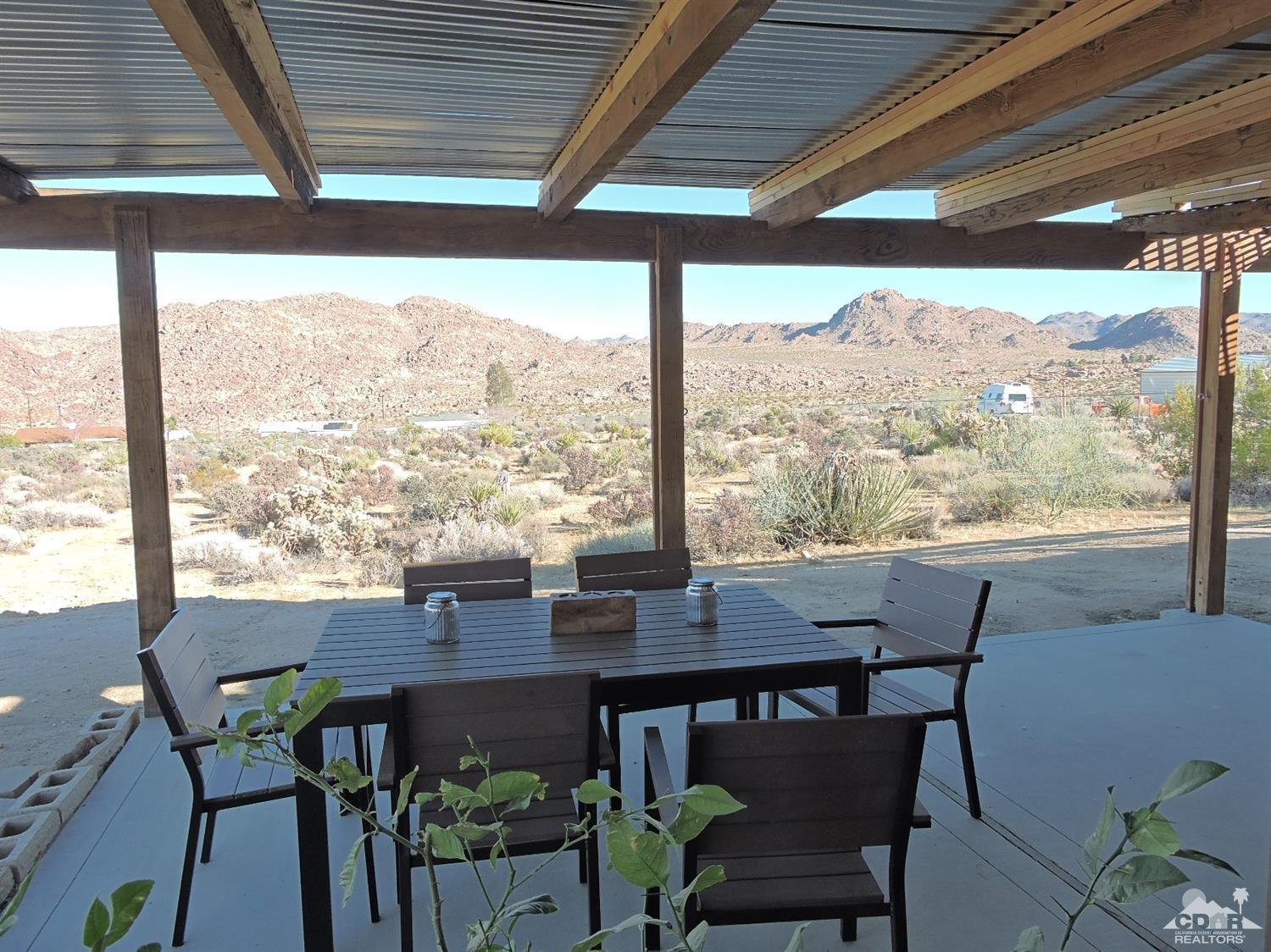 7369 Sunset Road Joshua Tree, CA 92252 - Photo 4 of 37 a view of a patio with furniture and a backyard