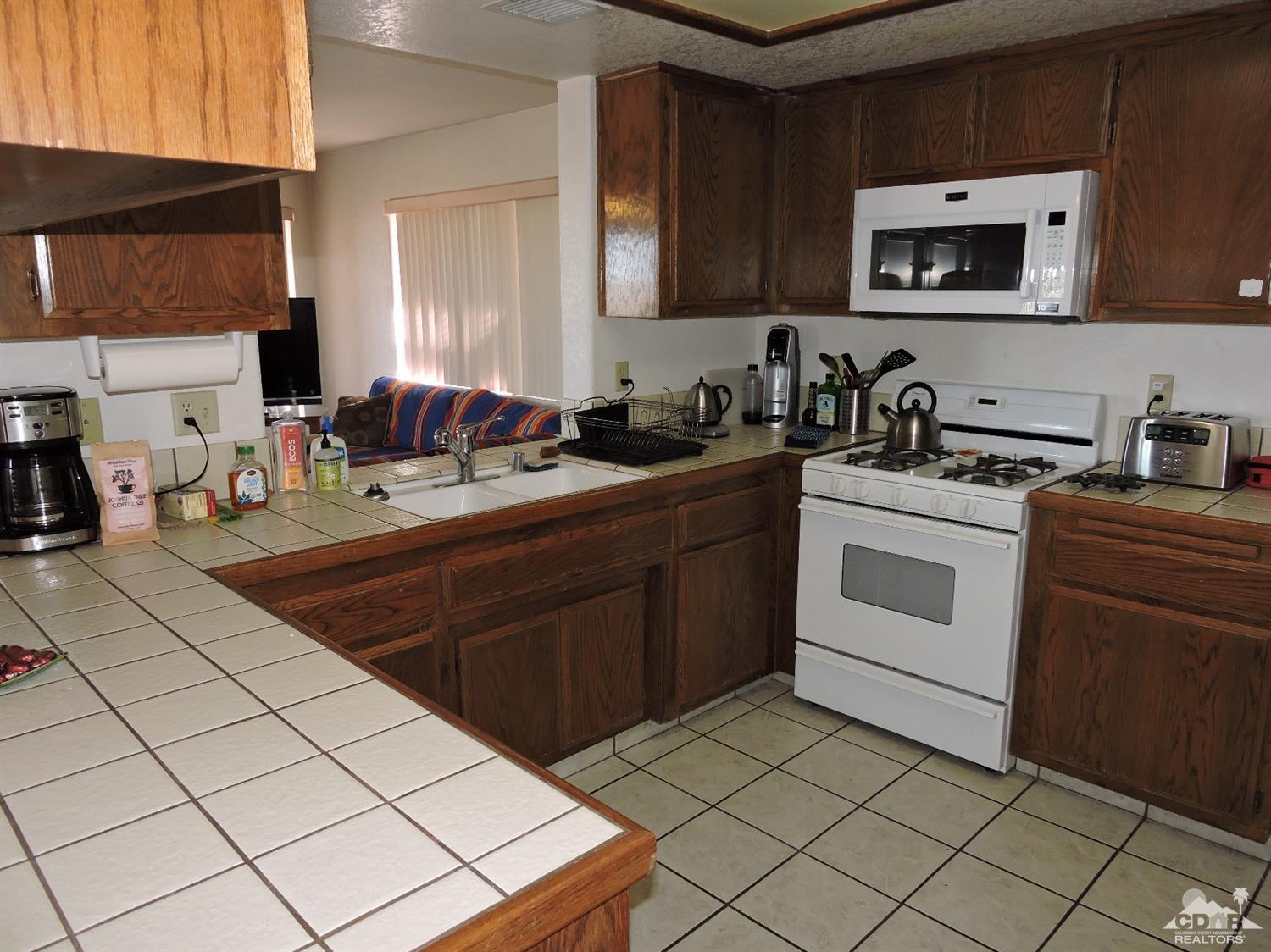 7369 Sunset Road Joshua Tree, CA 92252 - Photo 8 of 37 a kitchen with a sink stove top oven and cabinets