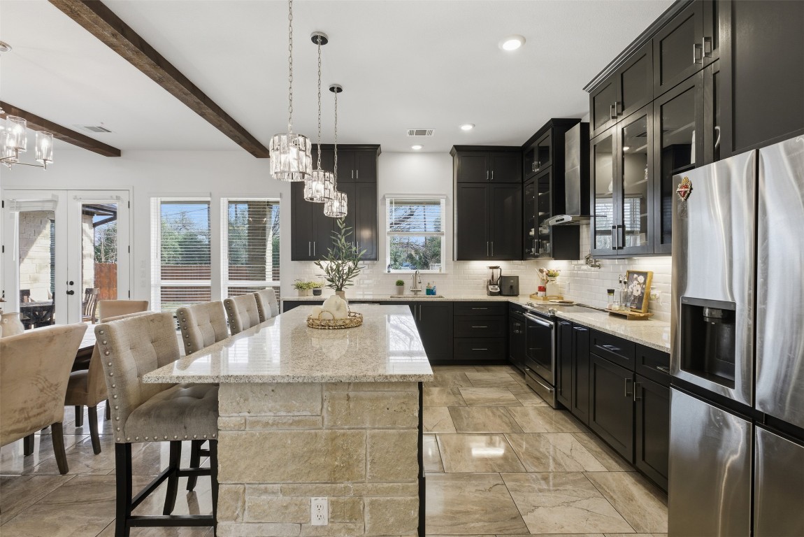 1905 South College Street Georgetown, TX 78626 - Photo 12 of 37 a large kitchen with stainless steel appliances kitchen island granite countertop a sink and cabinets
