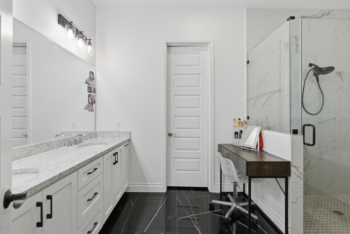 1905 South College Street Georgetown, TX 78626 - Photo 18 of 37 a bathroom with a granite countertop sink a mirror and a shower