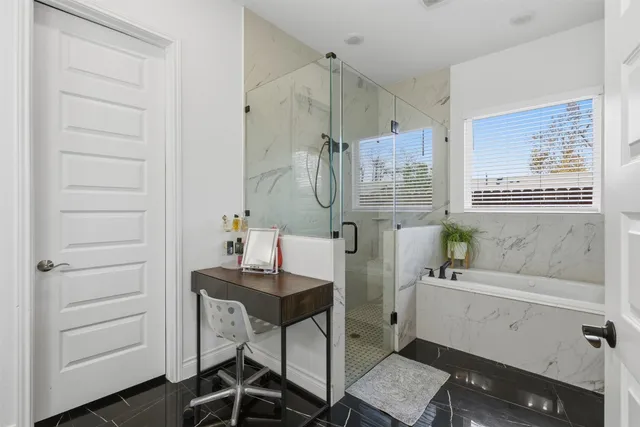 a bathroom with a granite countertop sink a mirror and a shower