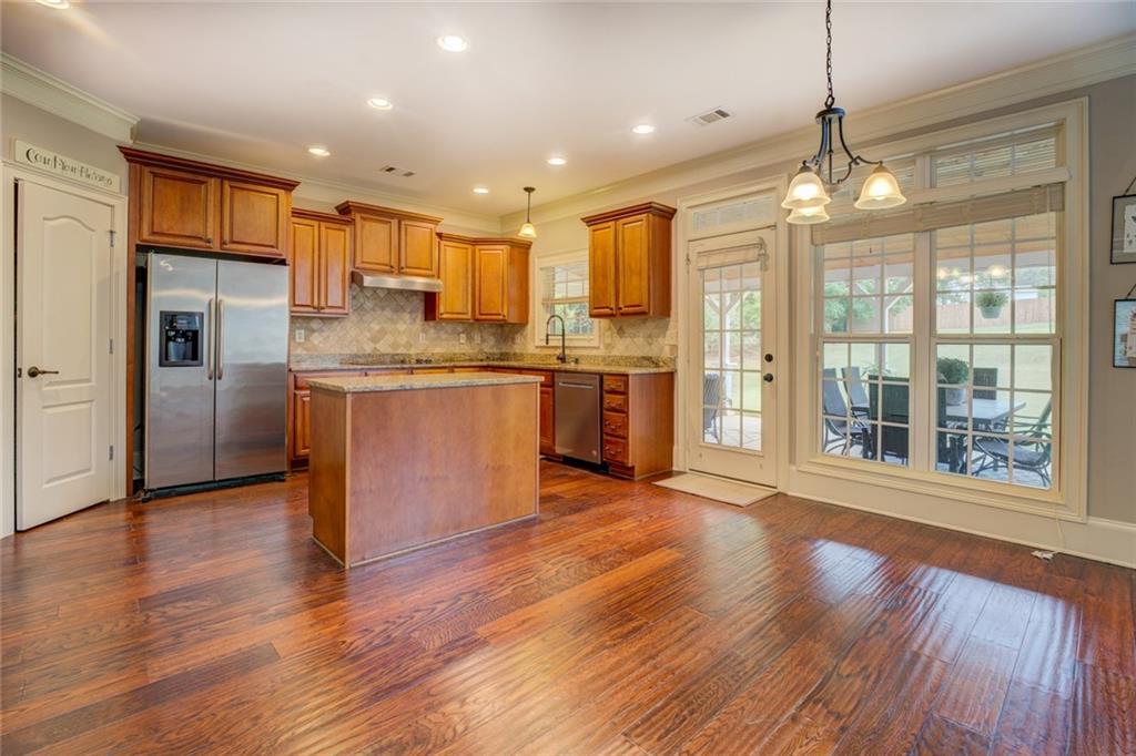 150 Alcovy Reserve Way Covington, GA 30014 - Photo 31 of 70 a open kitchen with stainless steel appliances granite countertop a refrigerator a sink dishwasher a stove and white countertops with wooden floor