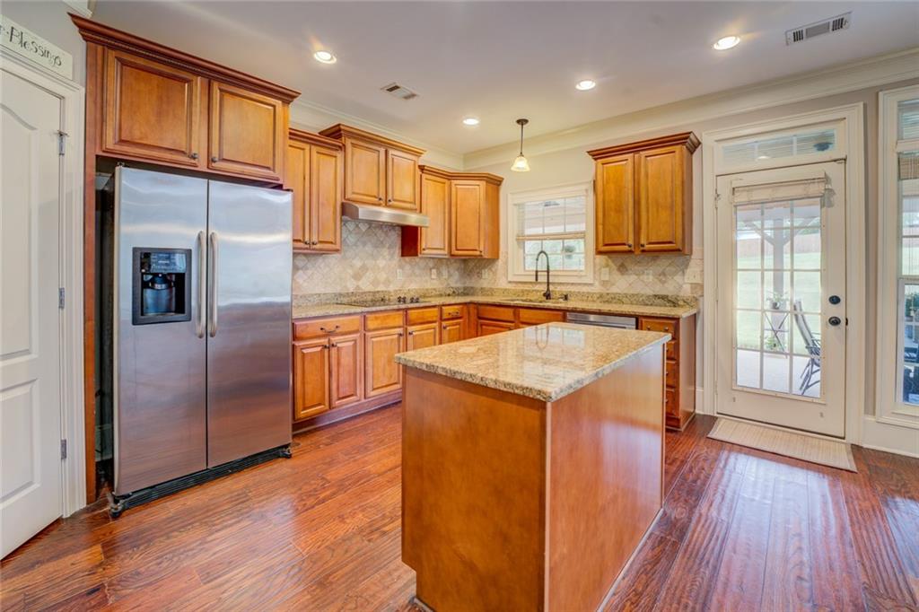150 Alcovy Reserve Way Covington, GA 30014 - Photo 33 of 70 a kitchen with stainless steel appliances granite countertop wooden cabinets and a refrigerator