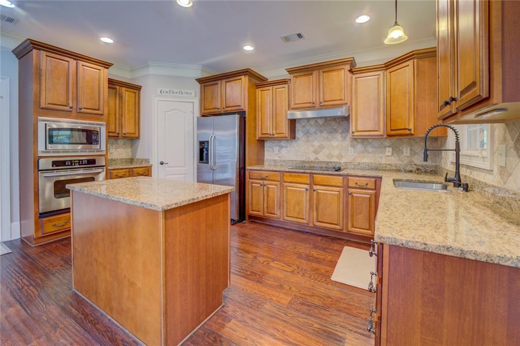 150 Alcovy Reserve Way Covington, GA 30014 - Photo 34 of 70 a kitchen with stainless steel appliances granite countertop wooden cabinets a sink dishwasher a stove and a refrigerator