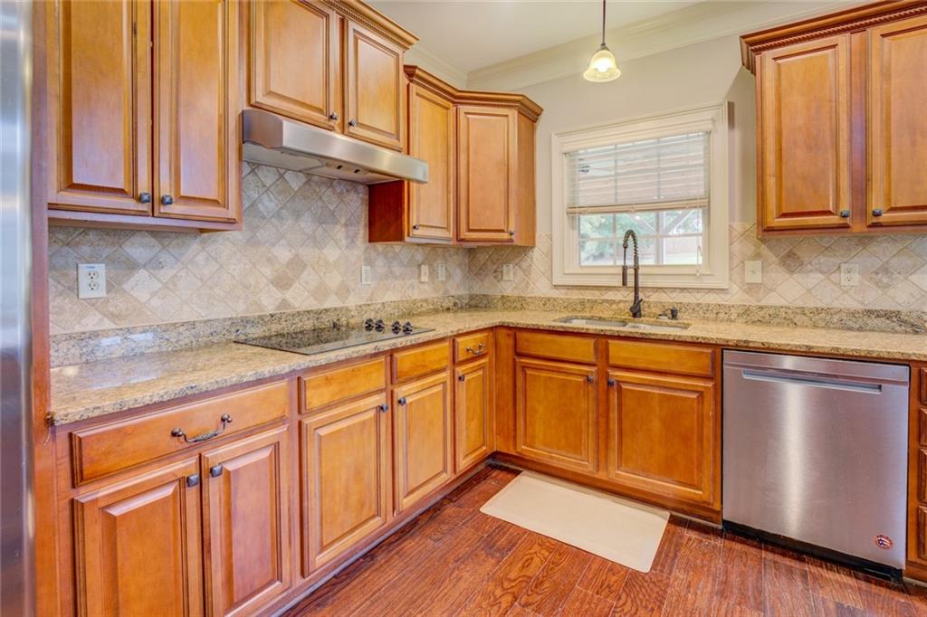 150 Alcovy Reserve Way Covington, GA 30014 - Photo 37 of 70 a kitchen with stainless steel appliances granite countertop a sink dishwasher stove and cabinets with wooden floor