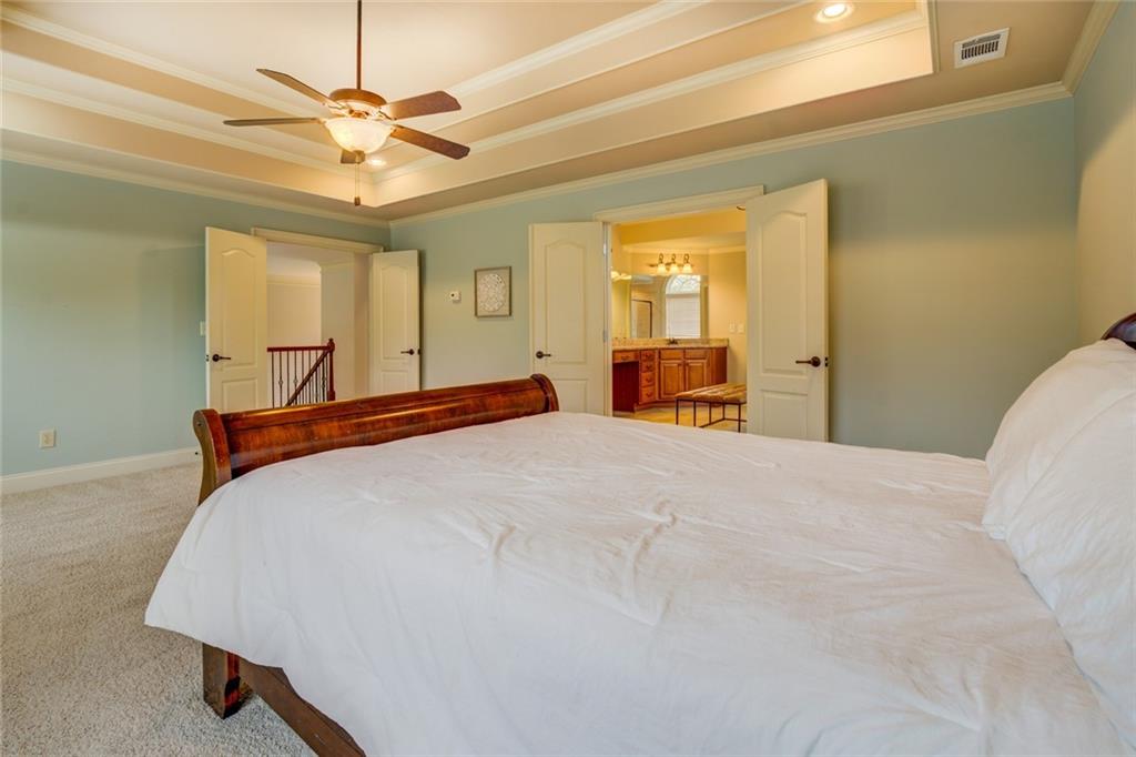 150 Alcovy Reserve Way Covington, GA 30014 - Photo 48 of 70 a bedroom with a large bed and a chandelier